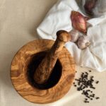 Mortier et pilon en bois d’olivier posés sur un tissu