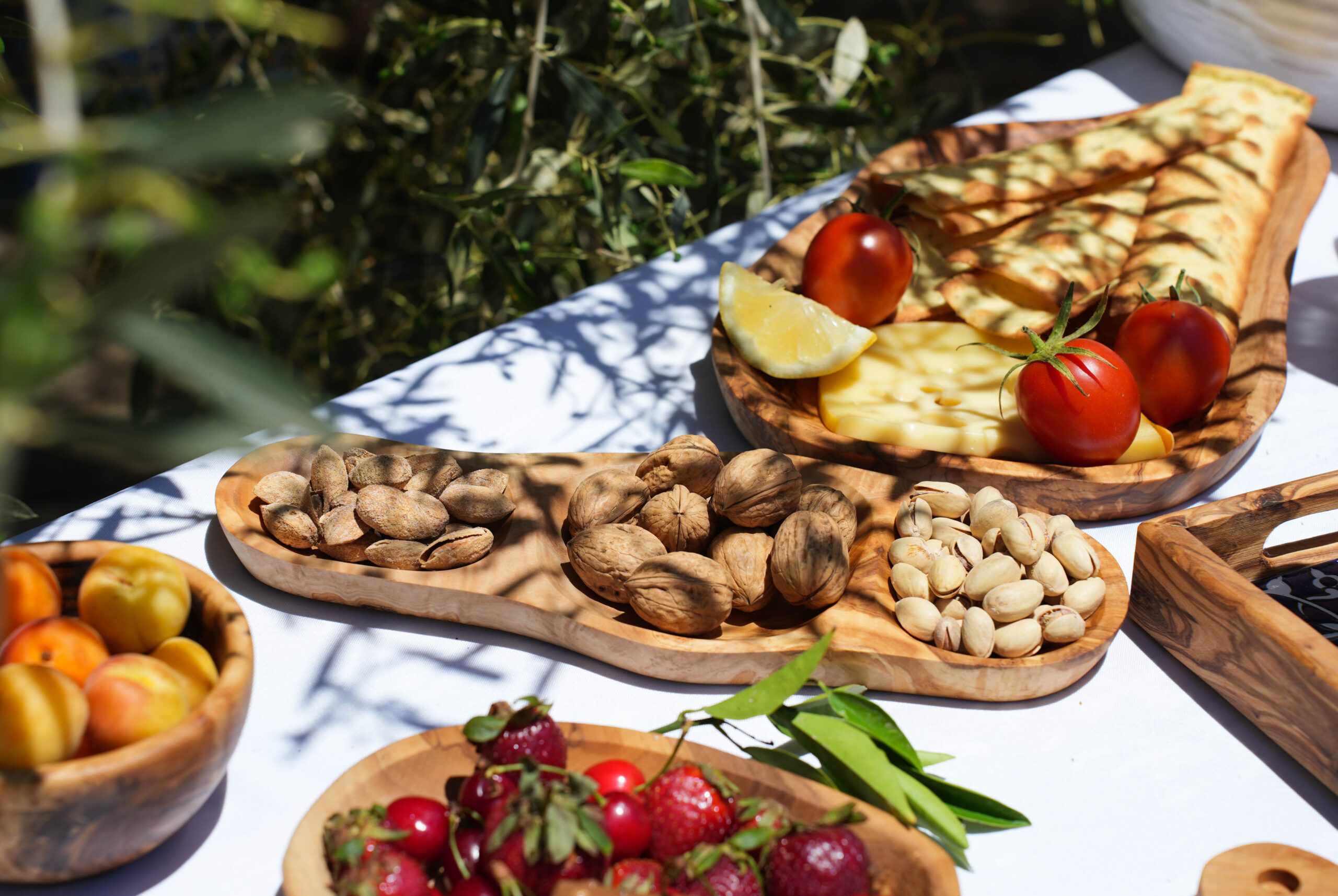 Table dressée avec des planches et plateaux en bois d’olivier