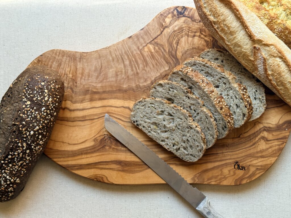 Planche à découper en bois d’olivier avec du pain tranché